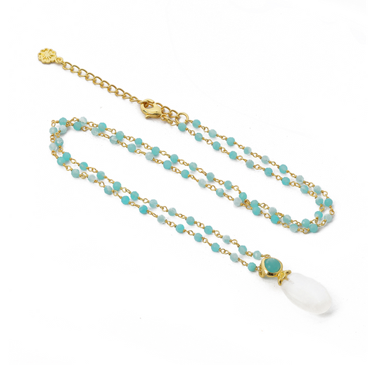 Necklace with turquoise beads and a white pendant on a white background