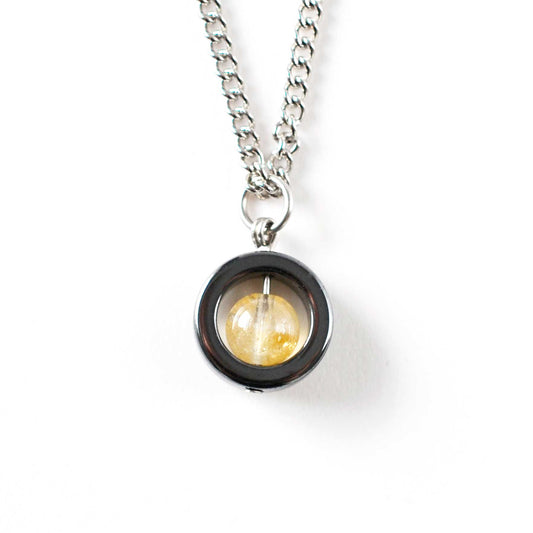 Necklace with a round pendant featuring a yellow gemstone on a white background