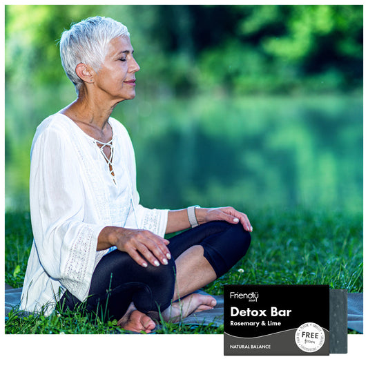 Woman sitting in nature with a 'Detox Bar' product displayed