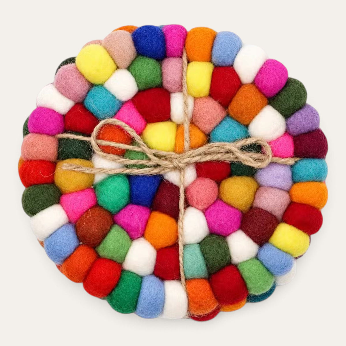 Set of four multicolour felt ball round coasters stacked and tied with natural jute twine, seen from above