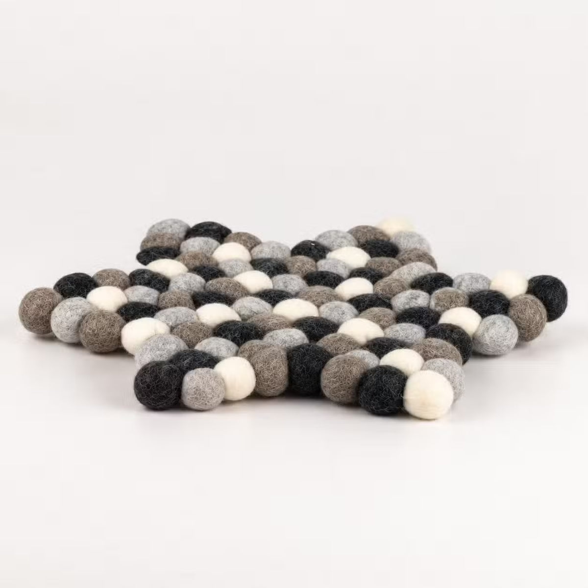 Side view of the grey felt ball star mat showing its thickness