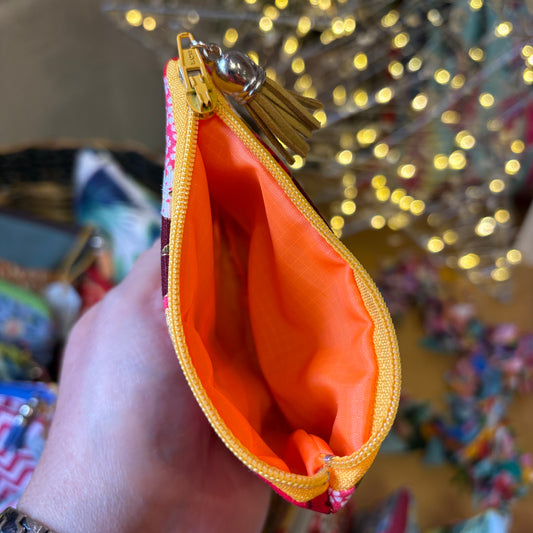 Isumi Red Japanese purse held open to show the bright orange Apricot Moon lining, a yellow zip and a mustard suede tassel