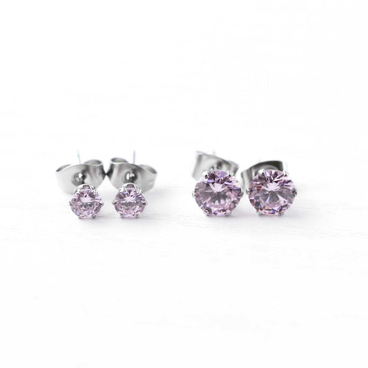 Pair of silver stud earrings with pink gemstones on a white background