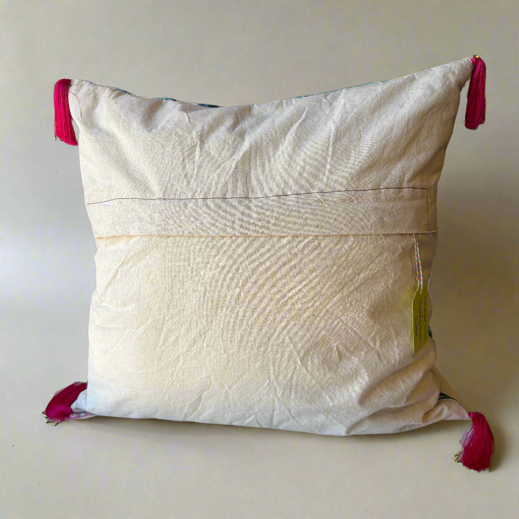 Rear view of the Rainforest cushion showing the plain cream back with an envelope opening, raspberry tassels at the corners and an Apricot Moon tag