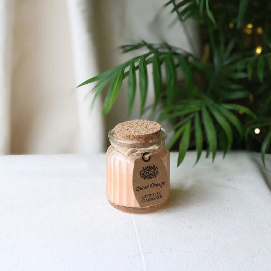 Close-up of the Spiced Orange soy candle in a ribbed glass jar with a cork lid and kraft tag