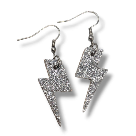 Silver glittery lightning bolt earrings on a white background
