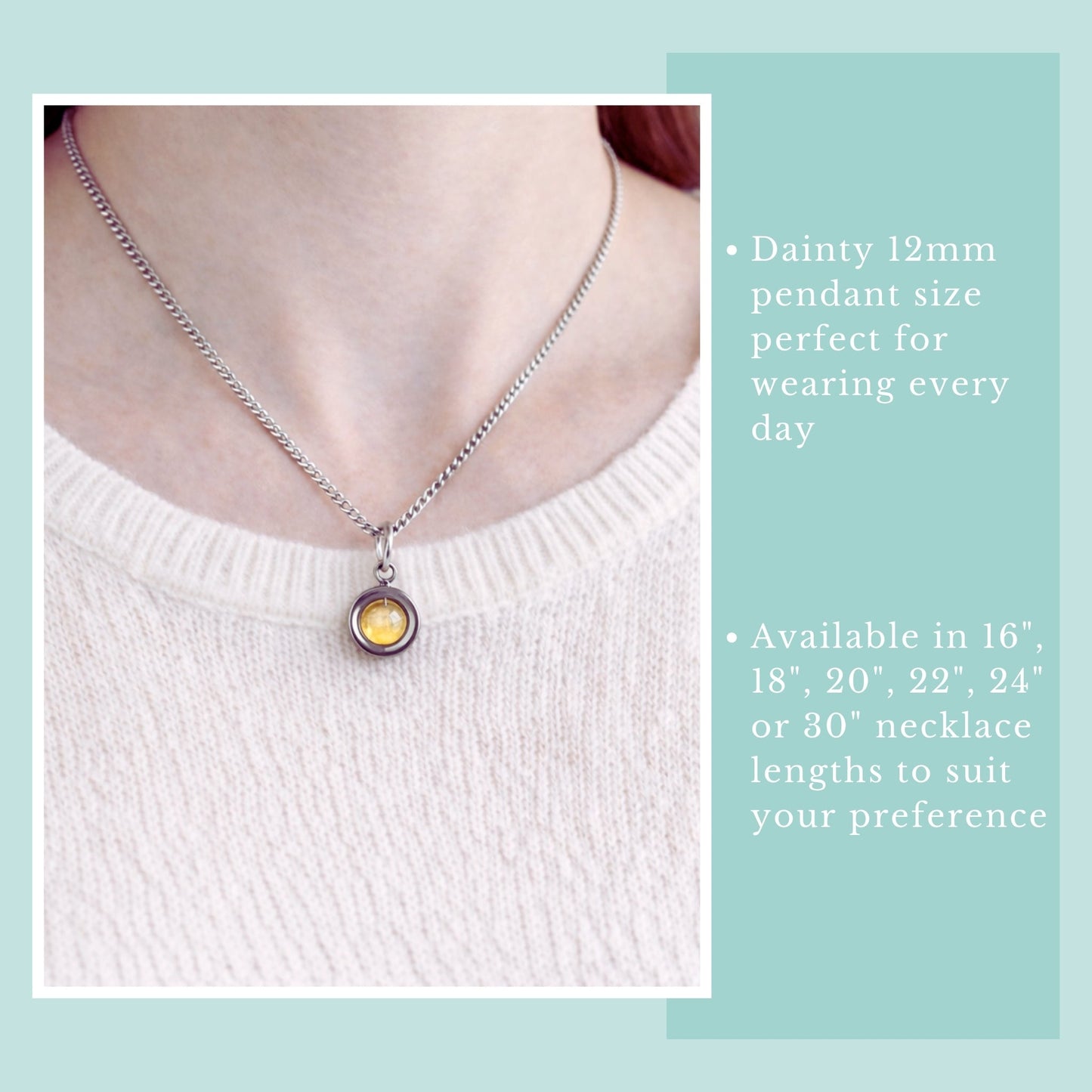 Necklace with a pendant on a person wearing a white sweater, against a light blue background.