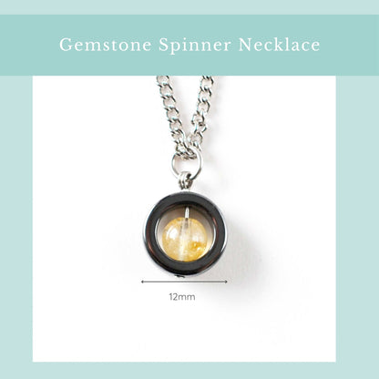 Gemstone spinner necklace with a yellow gemstone on a white background