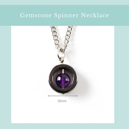Gemstone spinner necklace with purple gemstone on a white background