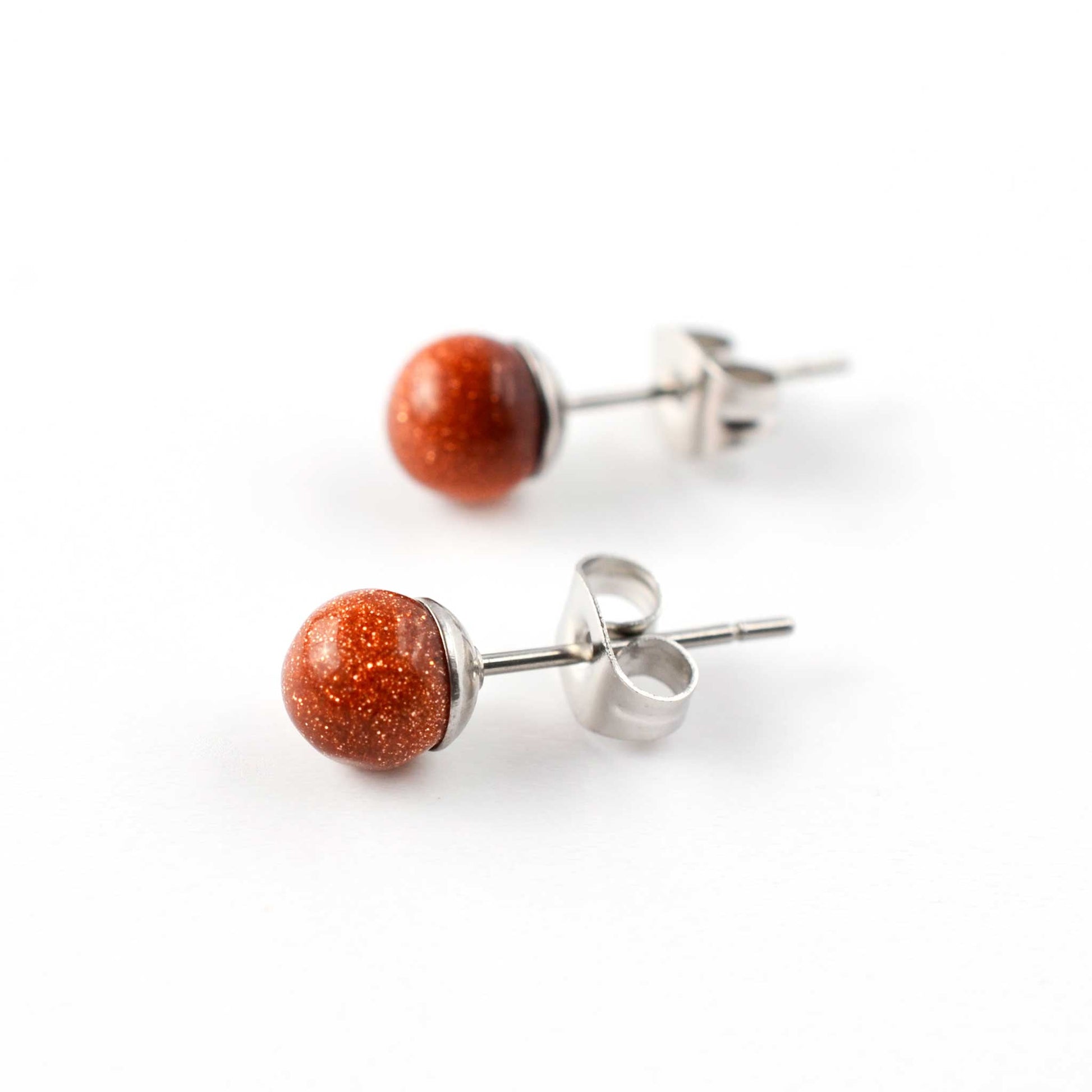 Pair of goldstone stud earrings on a white background
