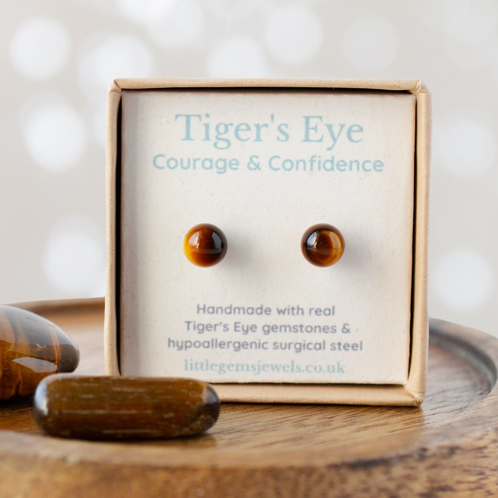 Tiger's Eye earrings in a box with 'Courage & Confidence' text on a wooden surface.