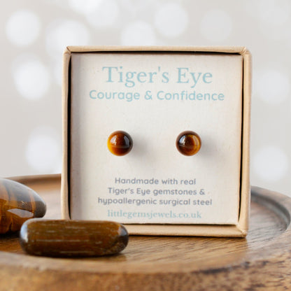 Tiger's Eye earrings in a box with 'Courage & Confidence' text on a wooden surface.