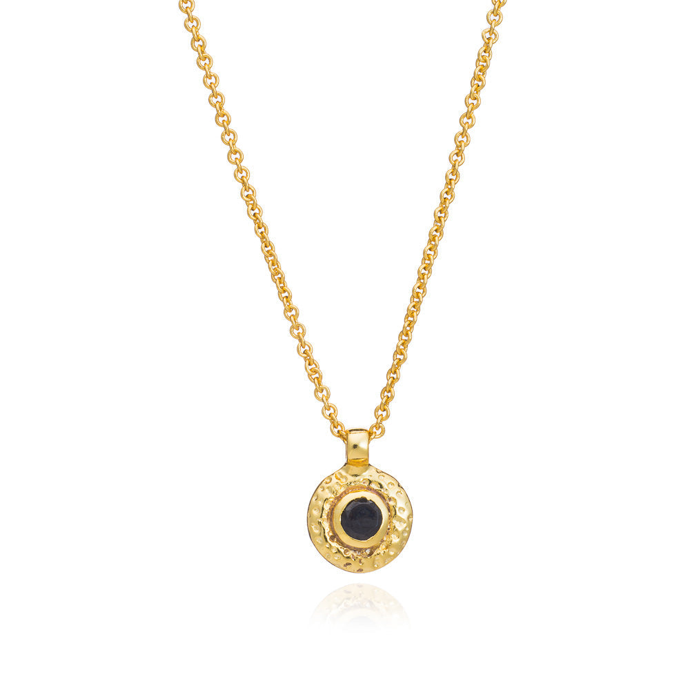 Gold necklace with a black pendant on a white background