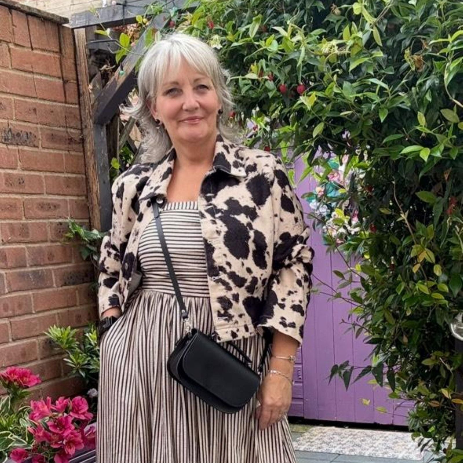 Woman standing outdoors with a floral background
