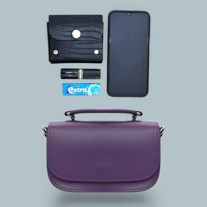 Purple handbag with phone, wallet, lipstick, and gum on a light gray background