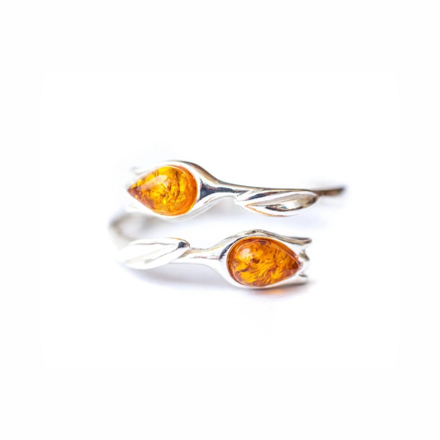 Silver ring with amber stones on a white background