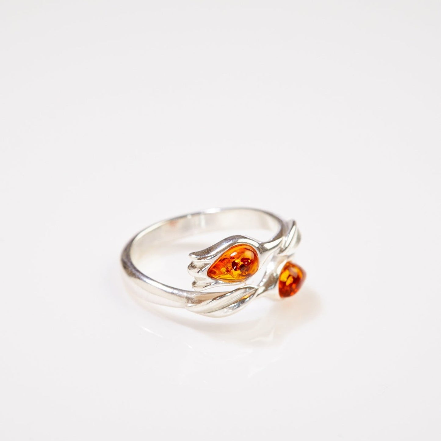 Silver ring with amber stones on a white background