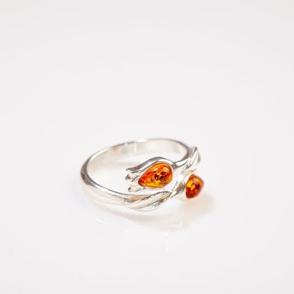 Silver ring with amber stones on a white background