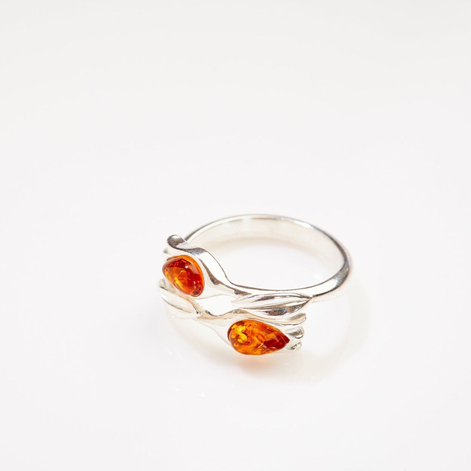 Silver ring with amber stones on a white background