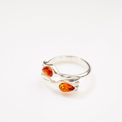 Silver ring with amber stones on a white background