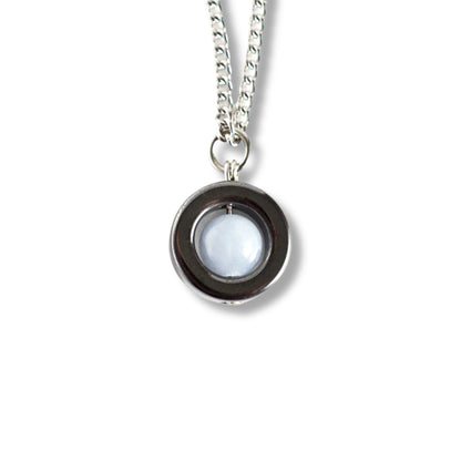 Silver necklace with a round pendant on a white background