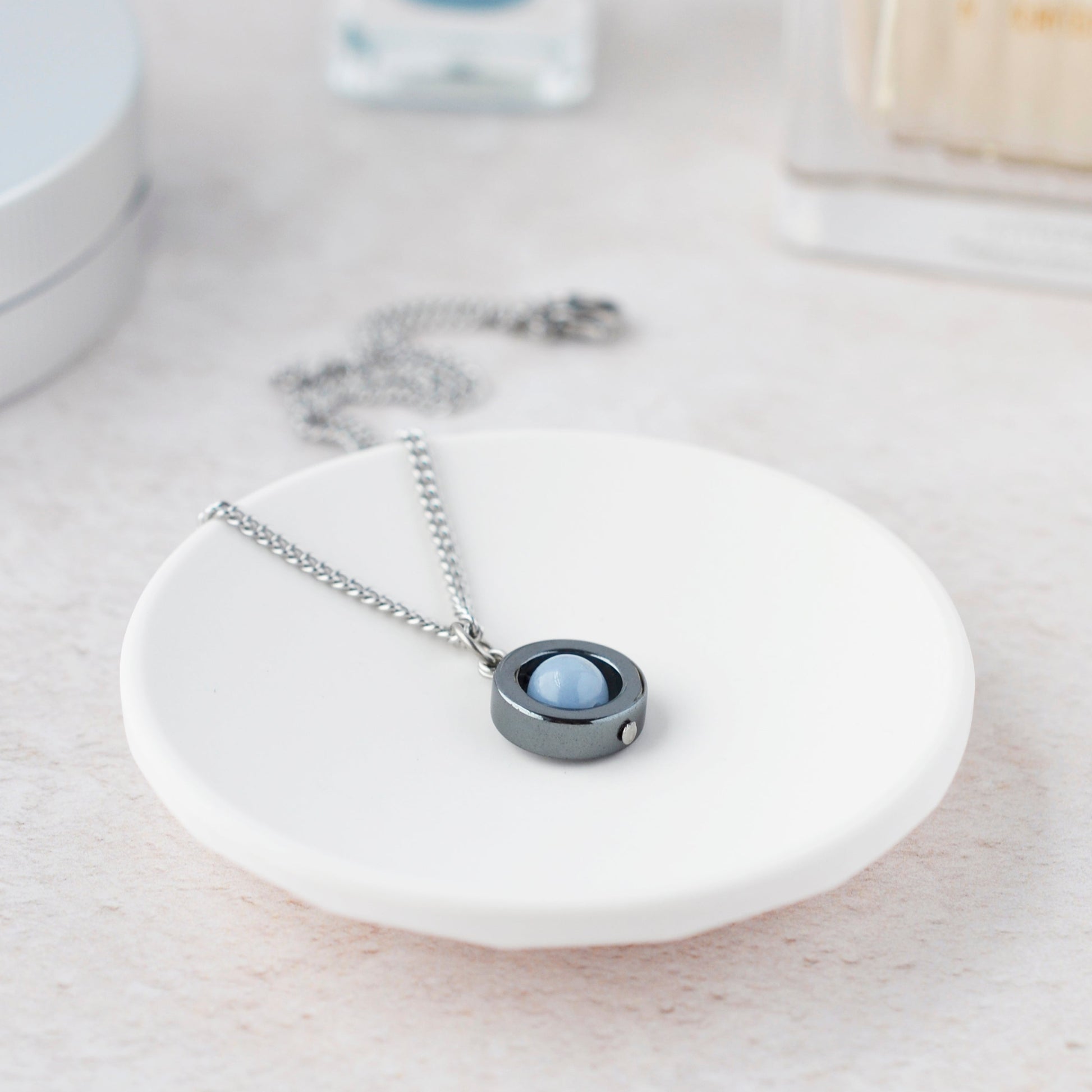 Necklace with a round pendant on a white dish