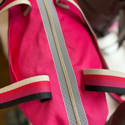 Close-up of the top of the Berry Riot shoulder tote showing the gold zip with black and white striped zip tape and pink, red, cream and black striped handles