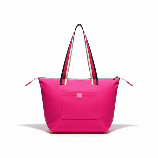 Berry Riot shoulder tote in bright pink cotton twill with pink, red, cream and black striped handles and a front pocket with a pink Apricot Moon label, front view studio shot, handmade in Dorset
