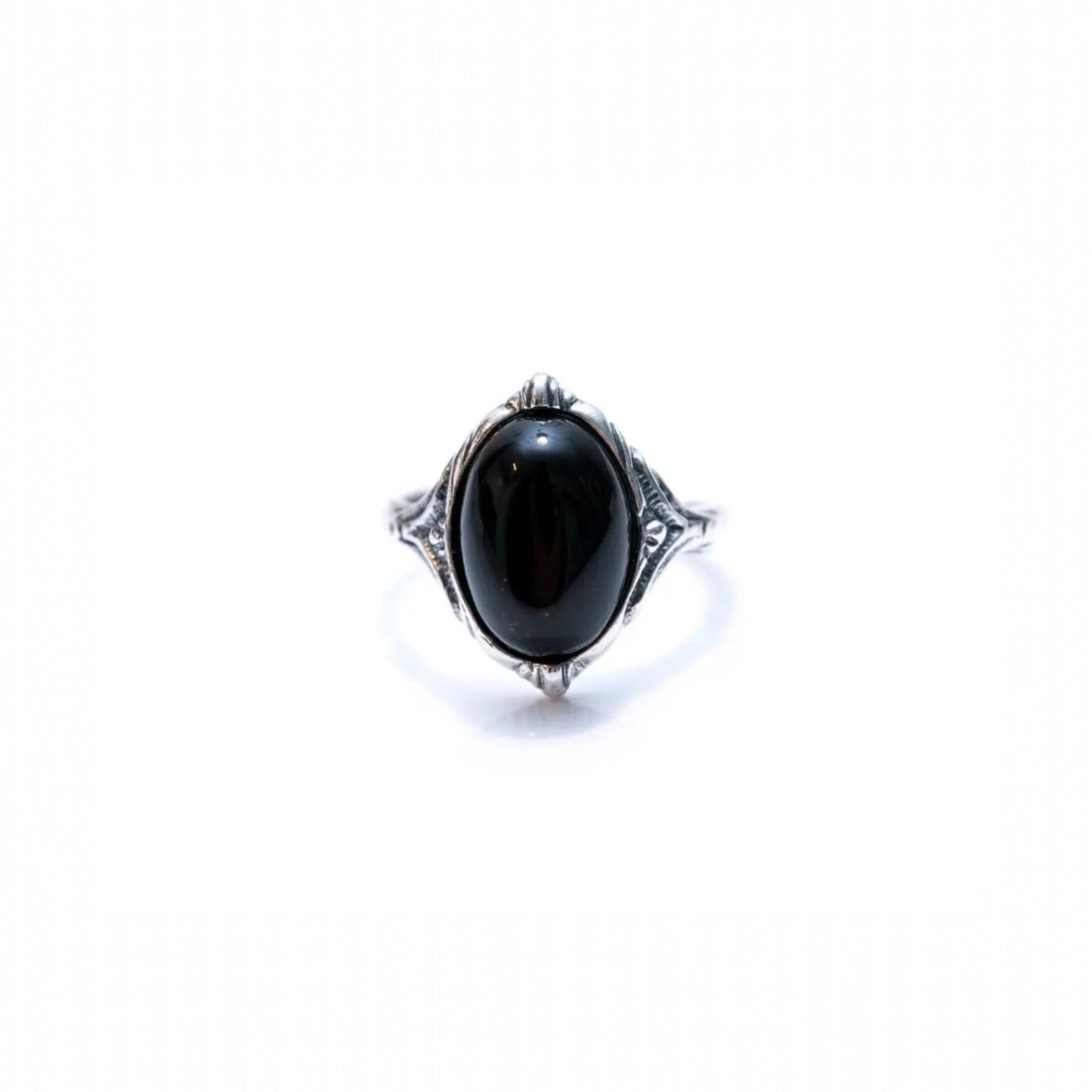 Silver ring with a black gemstone on a white background