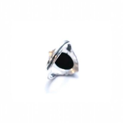 Silver ring with a black stone on a white background