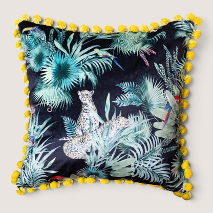 Deepest Jungle velvet cushion with acid yellow pompoms, studio front view showing the black velvet jungle print with a leopard, parrots and palm leaves, handmade in Dorset by Apricot Moon