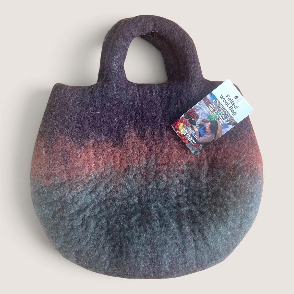 Back of the Fairy Garden Felted Bag in plain shaded brown, plum and green felt with an Ancient Wisdom hang tag