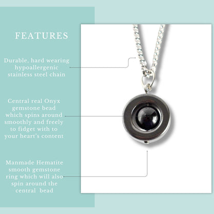 Necklace with central onyx gemstone bead and hypoallergenic stainless steel chain on a light blue background.