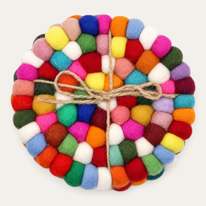 Set of four multicolour felt ball round coasters stacked and tied with natural jute twine, seen from above