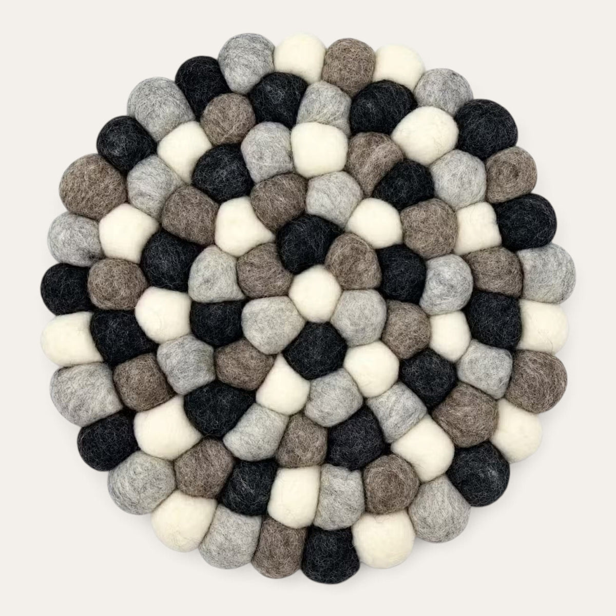Grey felt ball round placemat seen from above, in charcoal, grey, taupe and cream wool balls