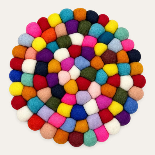 Multicolour felt ball round placemat seen from above, in a rainbow mix of wool balls