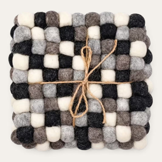 Set of four grey felt ball square coasters stacked and tied with natural jute twine, seen from above