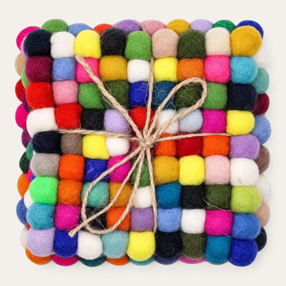 Set of four multicolour felt ball square coasters stacked and tied with natural jute twine, seen from above