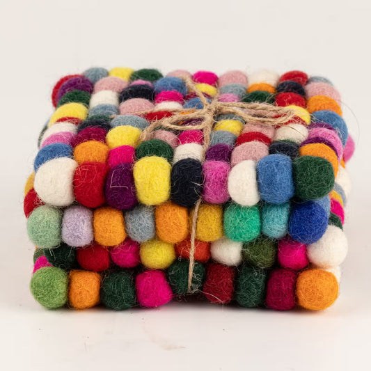 Side view of four multicolour felt ball square coasters stacked and tied with jute twine