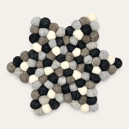 Grey felt ball star-shaped centre mat seen from above, in charcoal, grey, taupe and cream wool balls