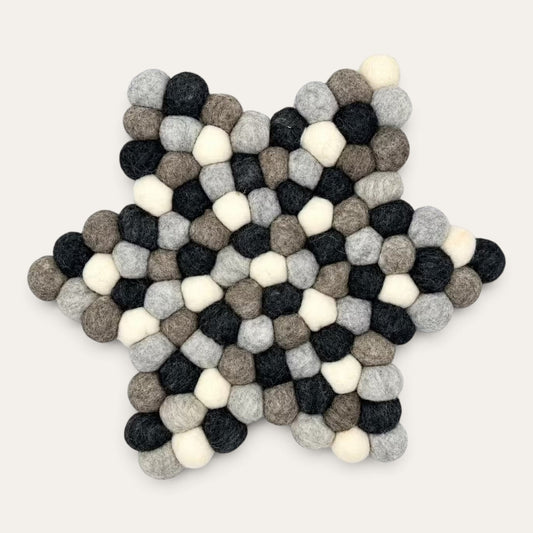 Grey felt ball star-shaped centre mat seen from above, in charcoal, grey, taupe and cream wool balls
