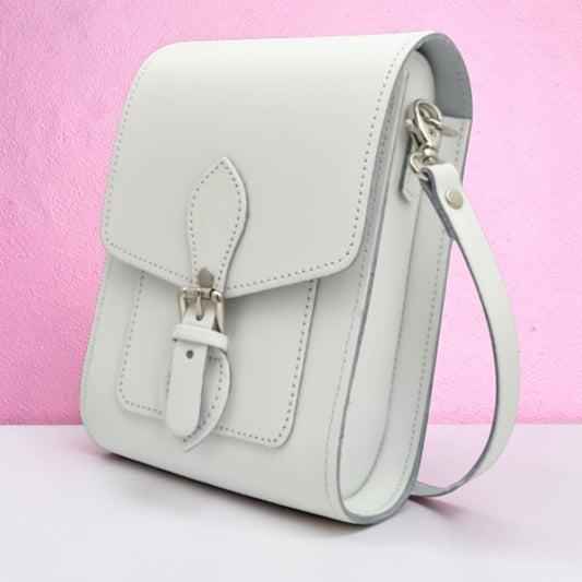 Light blue handbag with a strap on a pink background