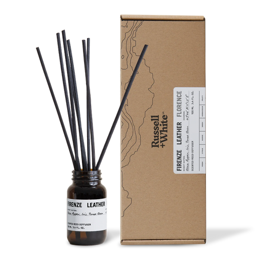 Diffuser bottle with black sticks and cardboard box labeled 'Firenze Leather' by Russell & White on a white background.