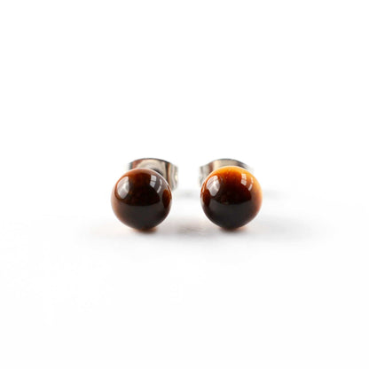 Pair of round earrings with brown and black color on a white background