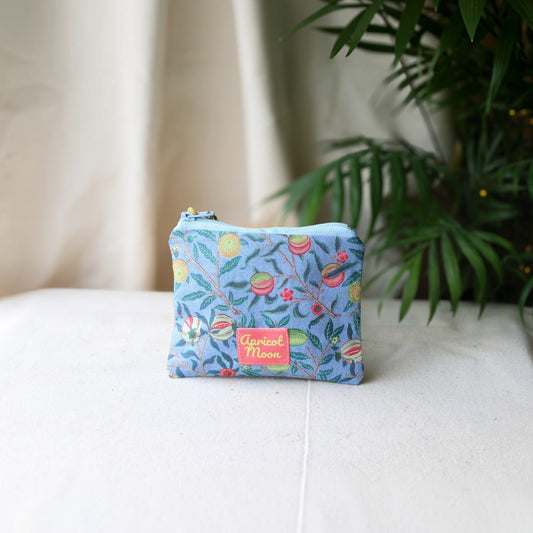 Garden Fruits purse in a William Morris fruit print on blue, with a coral zip and peach tassel, angled view