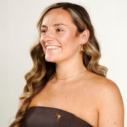 Woman with long wavy hair wearing a strapless top against a plain background