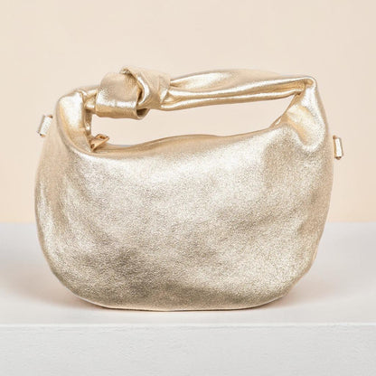 Gold metallic handbag on a light background