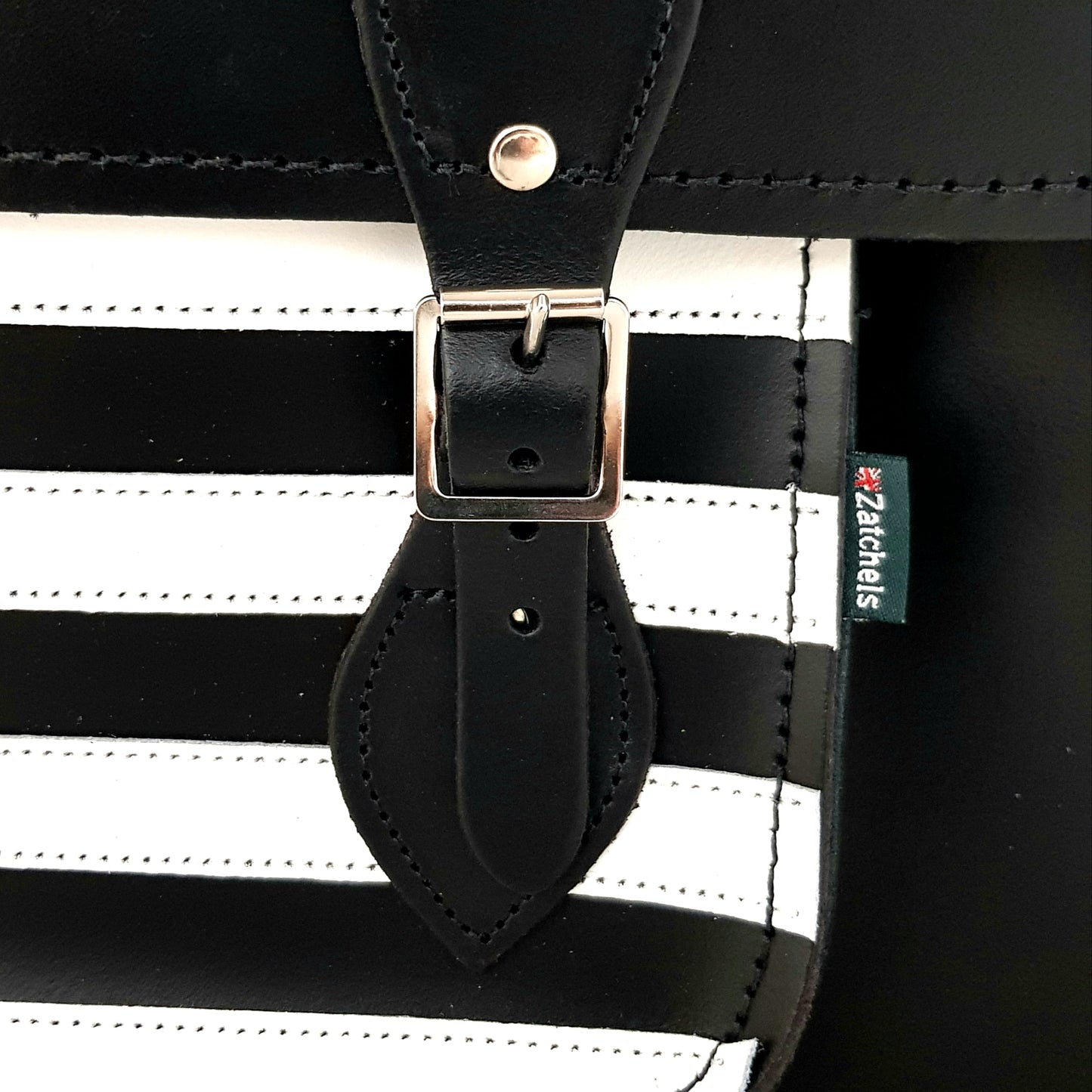 Black and white striped bag with a leather strap and visible brand logo.