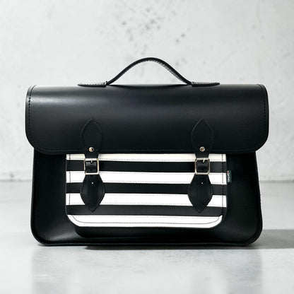 Black leather satchel with a white stripe design on a light gray background