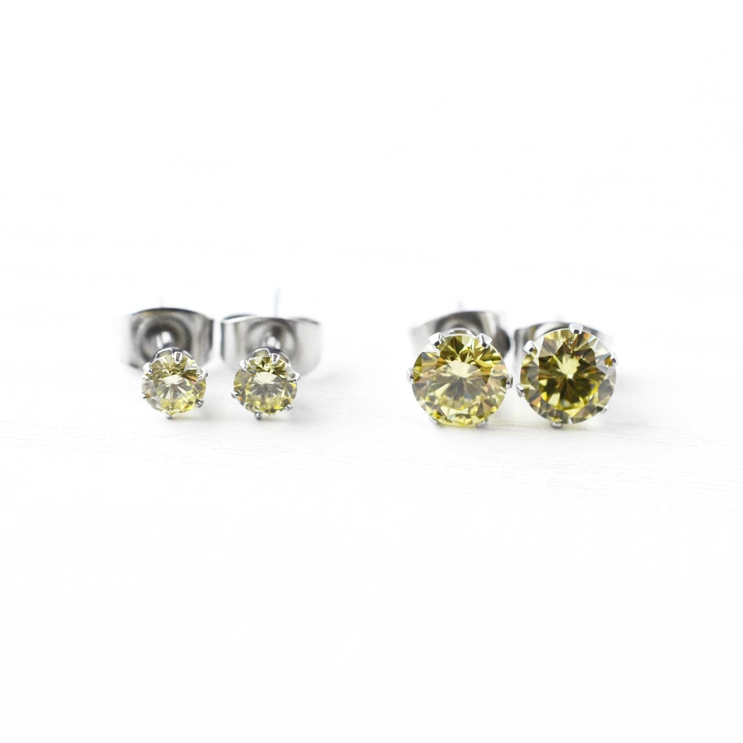 Pair of yellow gemstone stud earrings on a white background